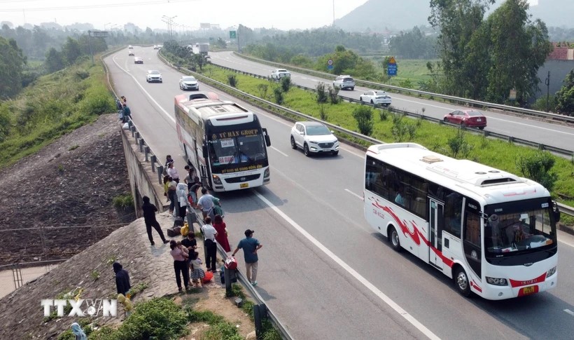 Xe khách dừng đón khách tại km26 trên tuyến cao tốc Nội Bài-Lào Cai (gần nút giao IC04 thuộc tỉnh Vĩnh Phúc). (Ảnh: Hoàng Hùng/TTXVN)