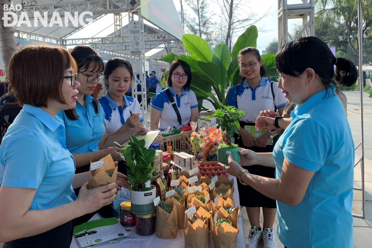 Các hội viên, người dân tham gia đổi rác tái chế lấy các chậu cây xanh. Ảnh: HOÀNG HIỆP