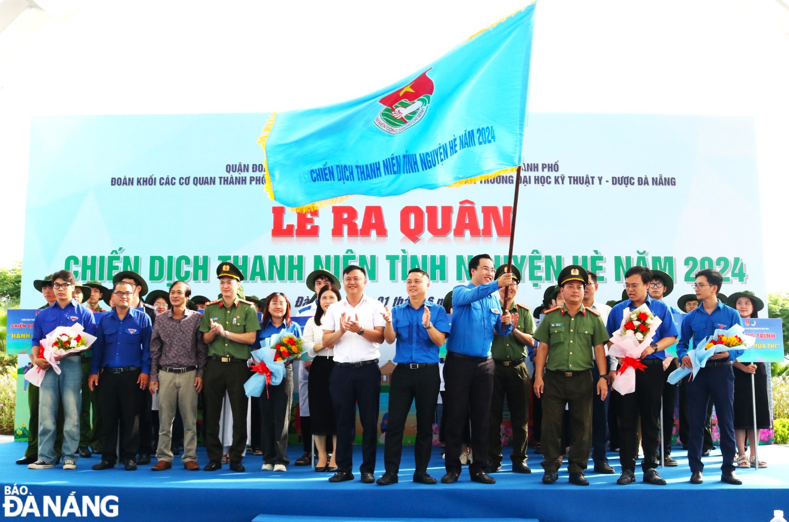 Representatives of units raising the flag to launch the 2024 summer youth volunteer campaign. Photo: N.Q