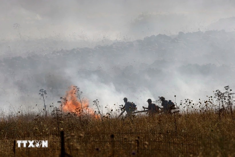 Lính cứu hỏa Israel dập lửa tại hiện trường vụ tấn công bằng rocket của lực lượng Hezbollah ở Liban nhằm vào ngoại ô thị trấn Katzrin thuộc Cao nguyên Golan, ngày 2-6. (Ảnh: AFP/TTXVN)