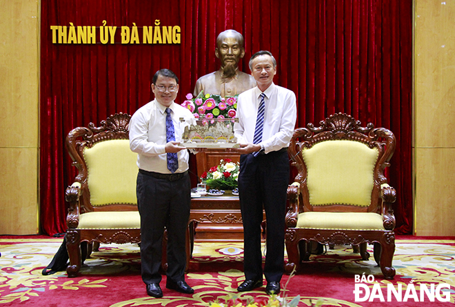 Head of the Da Nang Party Committee's Publicity and Training Department Doan Ngoc Hung Anh (right) presenting a souvenir to the delegation of the Lao National Book Publishing House