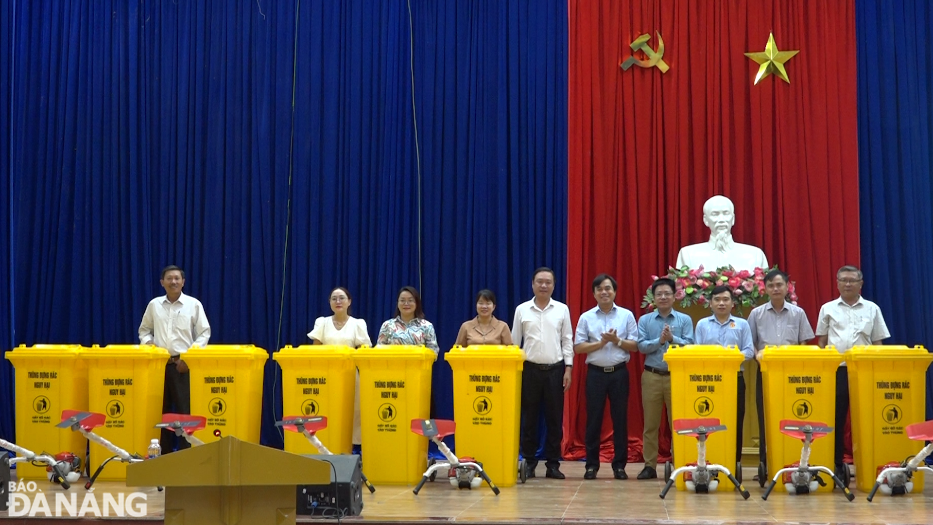Bí thư Huyện ủy Hòa Vang Tô Văn Hùng (thứ 6, từ trái sang) và lãnh đạo UBND huyện trao các thùng đựng rác nguy hại và máy cắt cỏ cho các địa phương để phục vụ hoạt động bảo vệ môi trường. Ảnh: HOÀNG HIỆP
