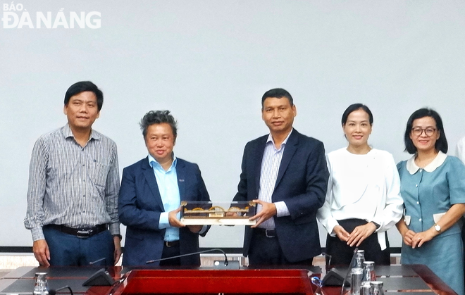 Permanent Vice Chairman of the Da Nang People's Committee Ho Ky Minh (center) presenting a souvenir to representatives of the Singapore Business Federation. Photo: M.Q