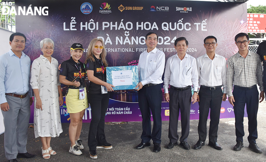 Chủ tịch UBND thành phố Lê Trung Chinh tặng quà động viên Công ty Tư vấn tổ chức pháo hoa Global 2000. Ảnh: THU HÀ