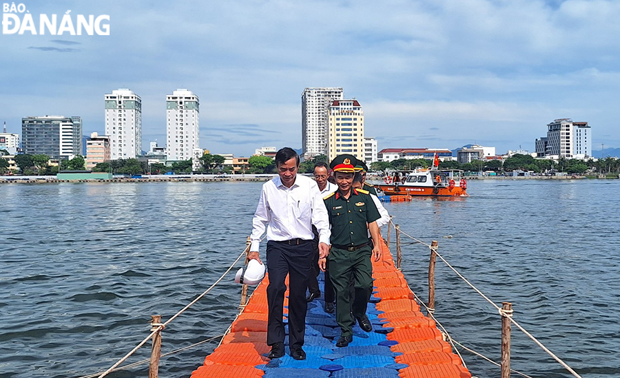 Chủ tịch UBND thành phố Lê Trung Chinh (ngoài cùng bên trái) kiểm tra trên sông và khu vực cầu phao thoát hiểm. Ảnh: THU HÀ