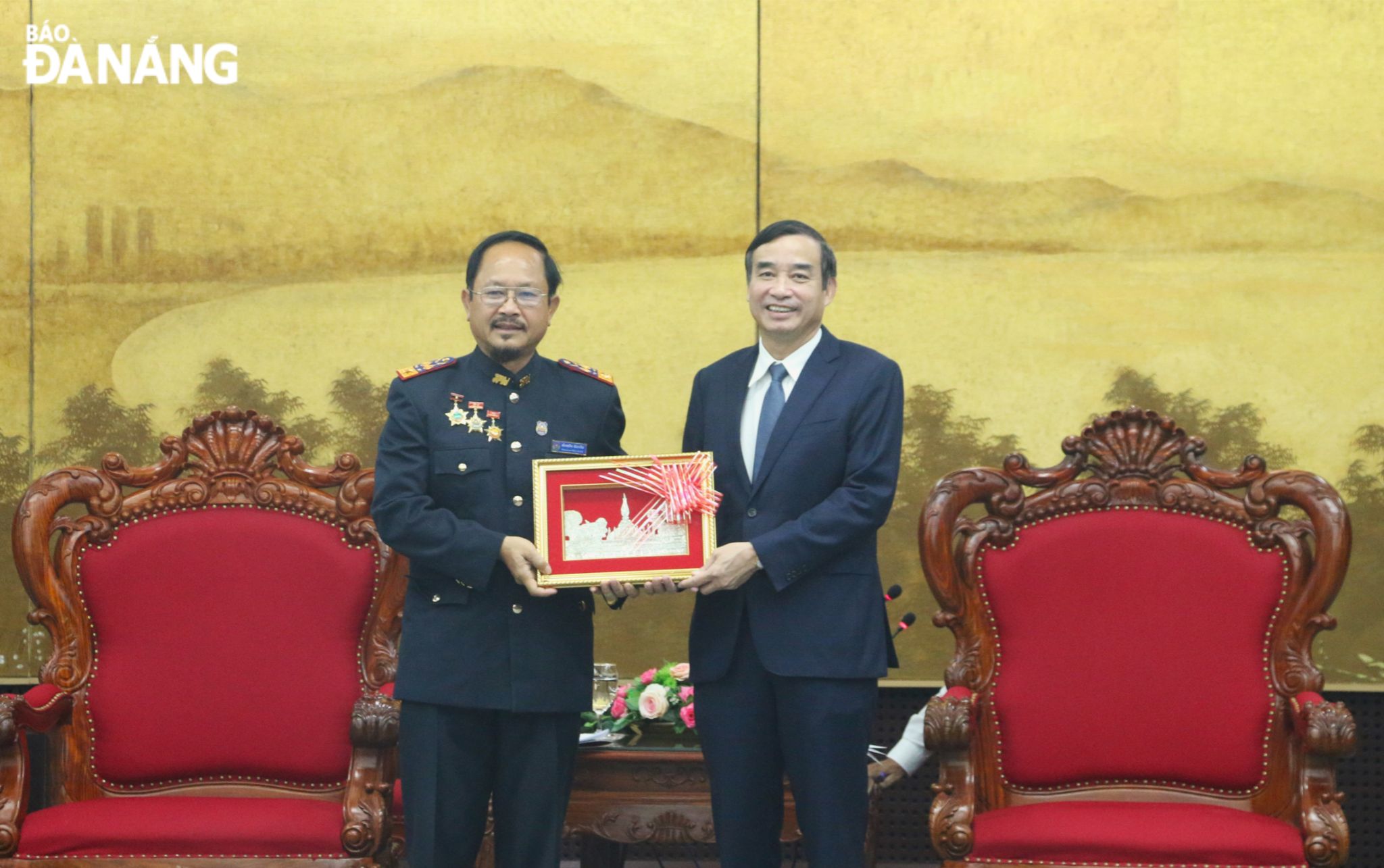 Chief Justice of the People’s Court of central Laos Phom Su Van Philachan (left) presenting a souvenir gift to Da Nang People’s Committee Chairman Le Trung Chinh