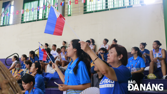 Volunteer Le Thi Thanh Tam and members of the Filipino sports delegation cheering for the basketball competition.