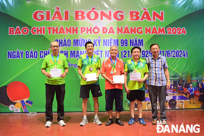 Phó Chủ tịch Thường trực Hội Nhà báo thành phố Lê Quang Á (bên trái) trao giải cho các vận động viên đoạt thành tích cao nội dung đơn nam. 