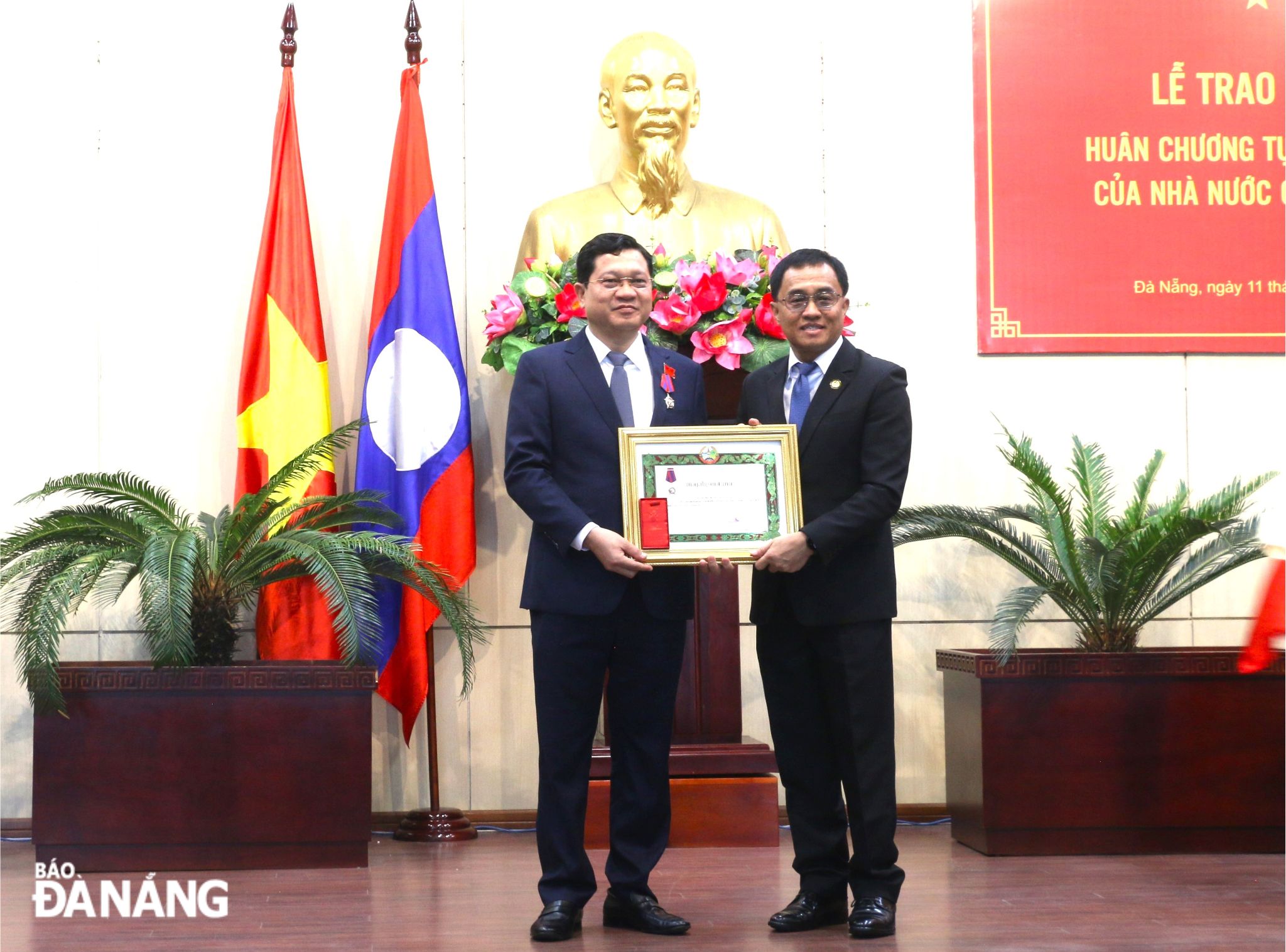 Secretary of the Party Committee and Governor of Sekong Province of Laos, Leklai Sivilay, (right) presenting the Third-class Freedom (Issara) Order of Laos to Permanent Vice Chairman of the Da Nang People's Council Tran Phuoc Son