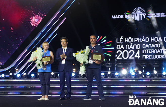 Da Nang People's Committee Vice Chairman Tran Chi Cuong (middle) awards campaign medals to the two teams.