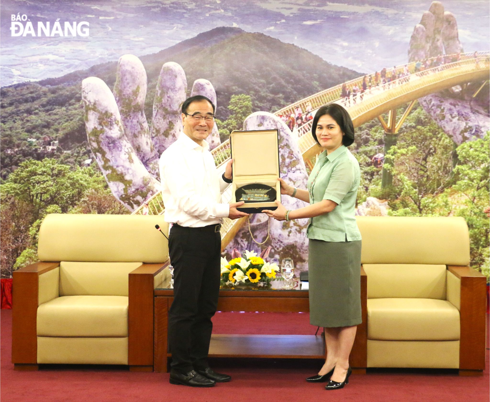 A representative from Yunnan Provincial Party Committee's Commission for Discipline Inspection (left) giving a sovenir gift to  Chairwoman of the Da Nang Party Committee's Inspection Commission Le Thi My Hanh 