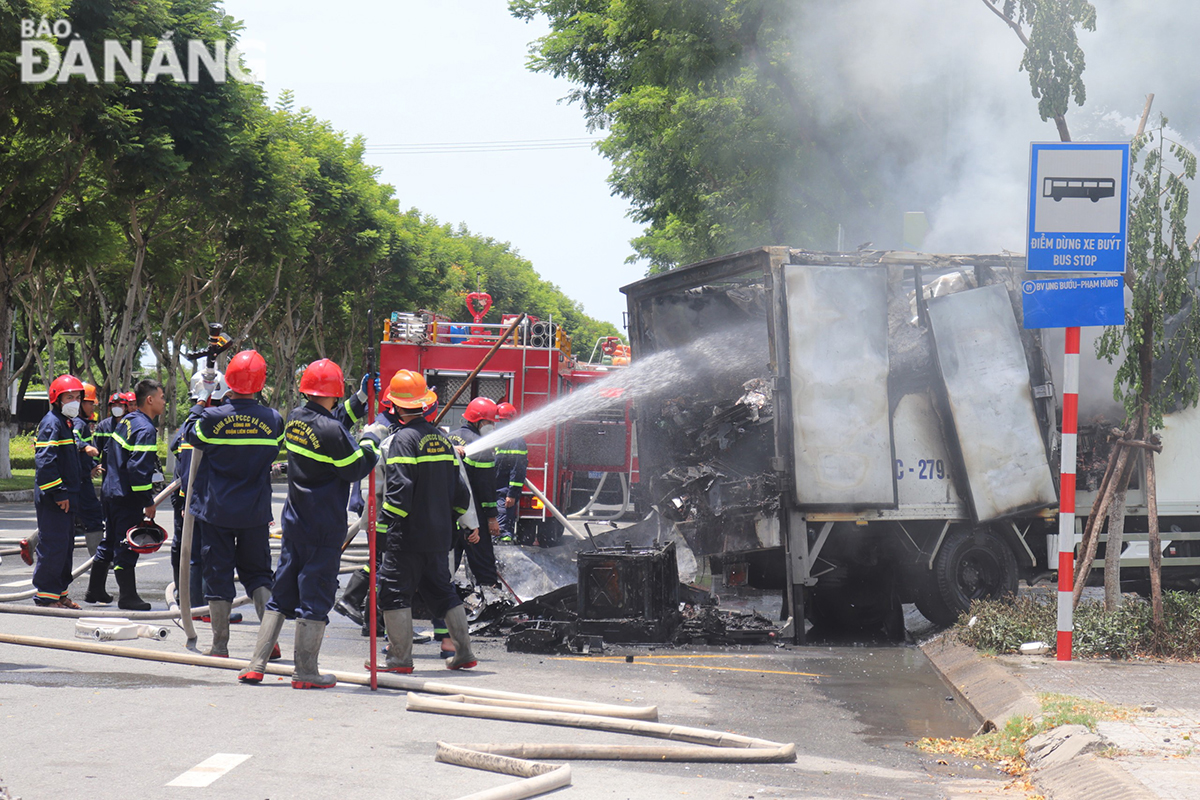 Lực lượng chức năng tổ chức chữa cháy cho xe tải gặp nạn.