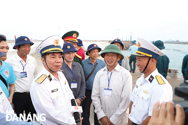 Ông Nguyễn Văn Long (thứ 2, bên phải sang) được đoàn công tác thành phố Đà Nẵng mời tham gia đoàn, ra đảo Song Tử Tây gặp con trai là Thiếu tá Nguyễn Quang Vinh (bên phải). Cuộc gặp đầy xúc động, thể hiện tốt chính sách hậu phương quân đội. Ảnh: G.P