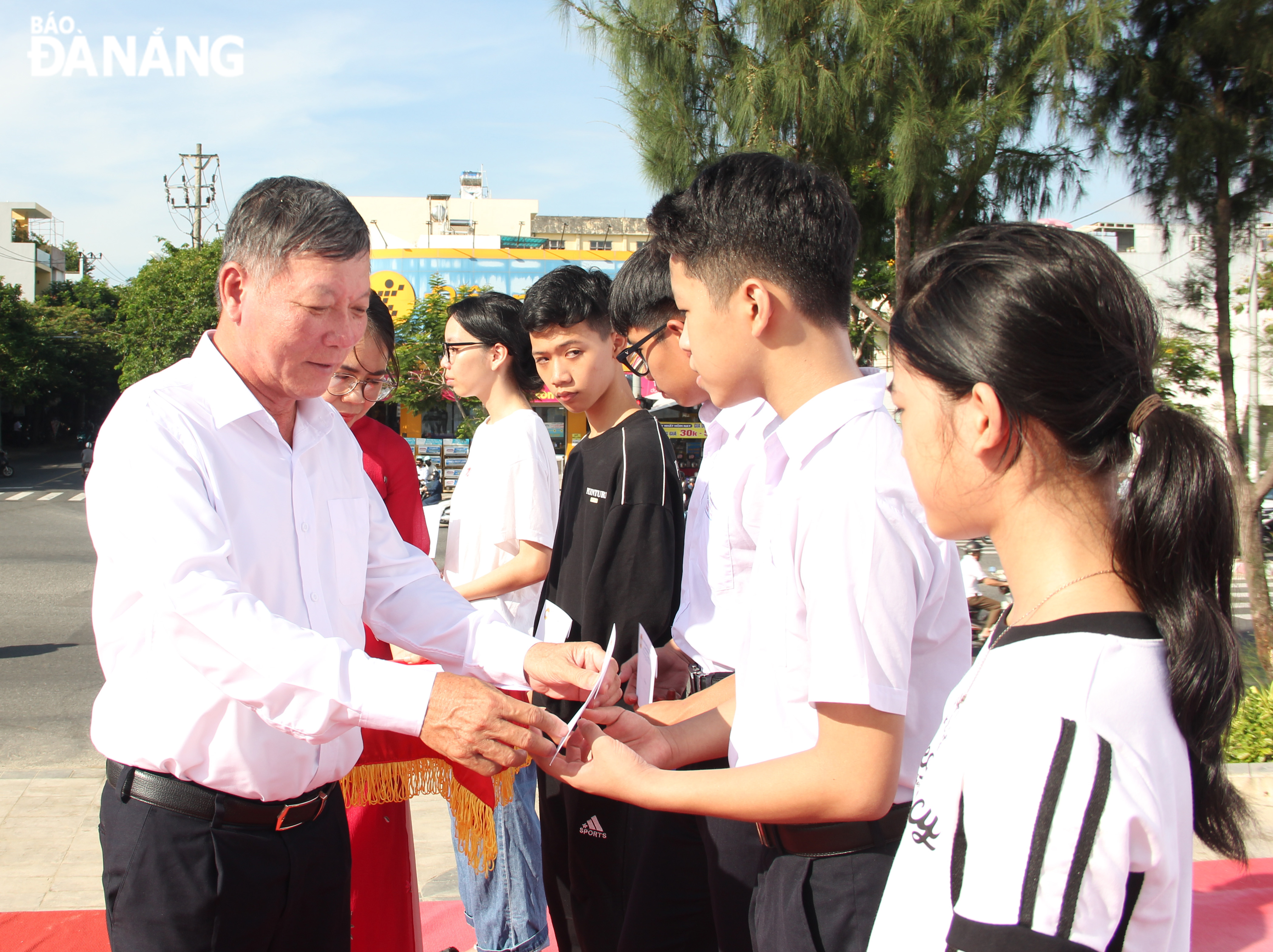 Trưởng ban Dân vận Thành ủy Lê Văn Trung trao học bổng cho các em học sinh có hoàn cảnh khó khăn tại quận Thanh Khê. Ảnh: X.HẬU