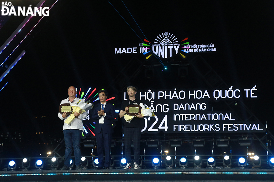 Da Nang People's Committee Vice Chairman Tran Chi Cuong (middle) awards campaign medals to the two teams.