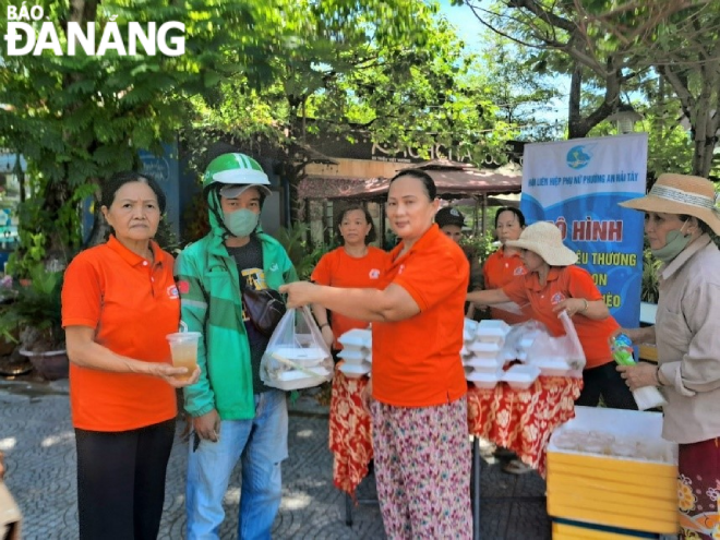 Officials, members, and women of An Hai Tay Ward distribute zero-cost meals to local poor labourers.