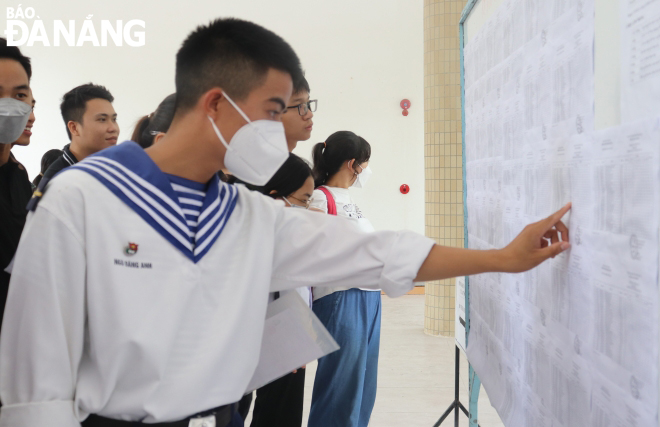 Candidates check the exam room layout diagram at the Phan Chau Trinh Senior High School in Da Nang.