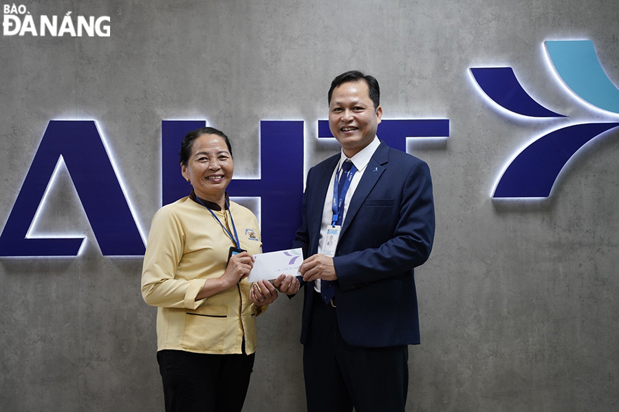 Ms. Tran Thi Huong (left) receives an award from the representative of Da Nang International Terminal in recognition of her good deed.