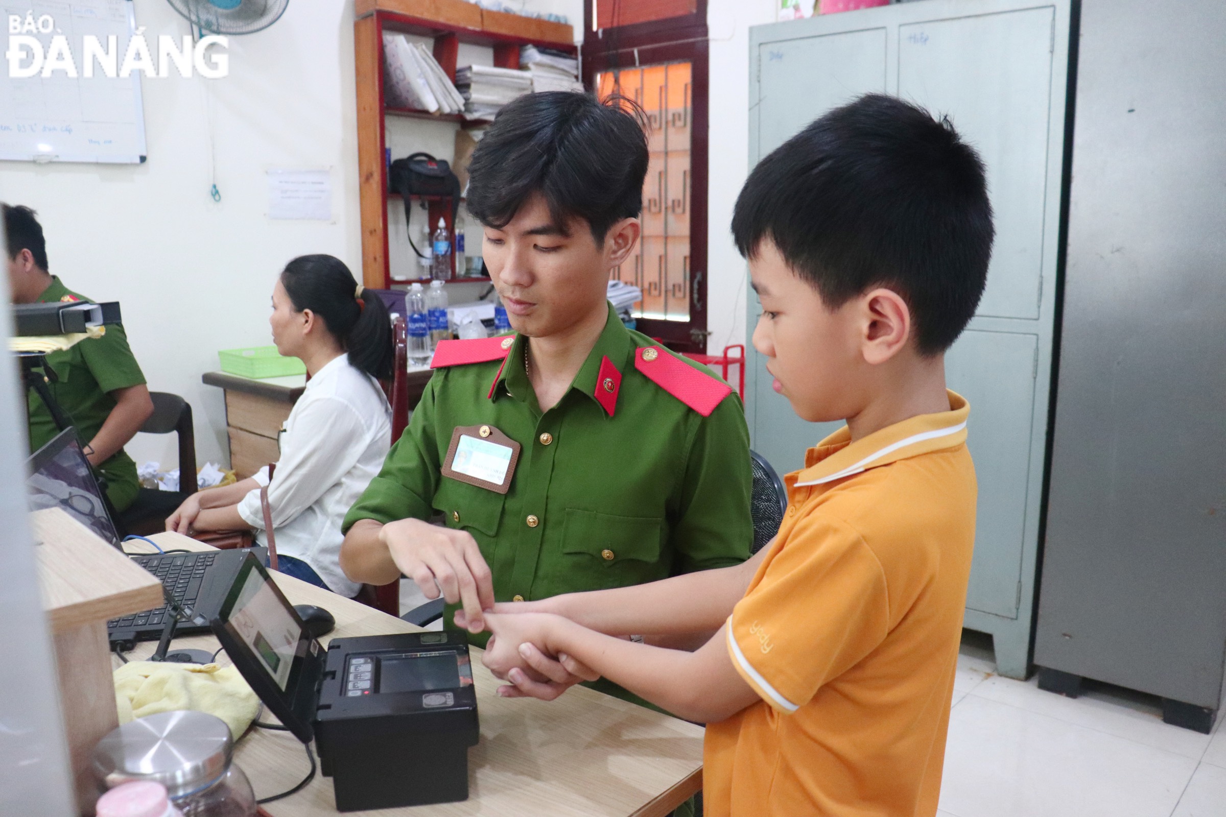 Police officers in Thanh Khe District receive fingerprint biometrics from a young citizen.