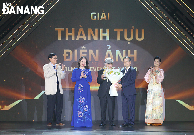 Vice President Vo Thi Anh Xuan (2nd, left) and Da Nang Party Committee Secretary Nguyen Van Quang (2nd, right) awarded the Film Achievement Award to Director, People's Artist Dang Nhat Minh. Photo: X.D