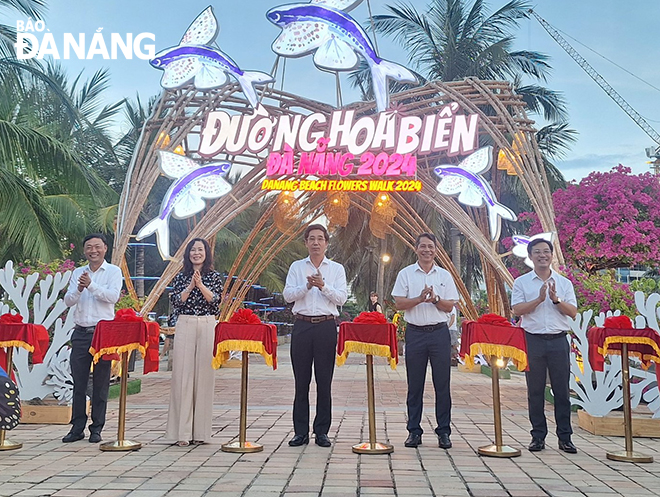 Da Nang People's Committee Vice Chairman Tran Chi Cuong (3rd, right) and the leaders of municipal departments and agencies cut the ribbon to inaugurate the 2024 Da Nang Beach Flower Street. Photo: THU HA