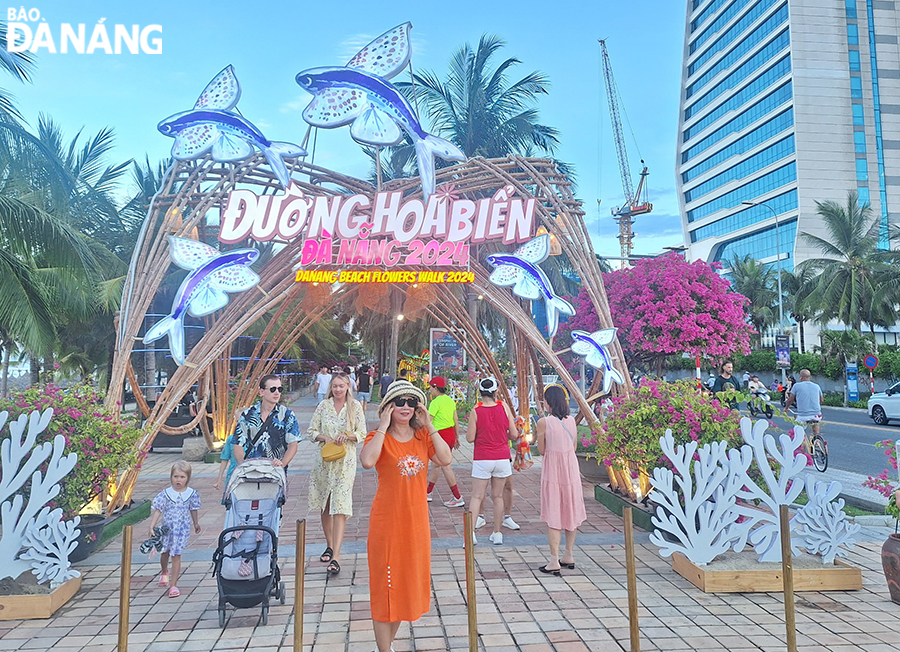 Tourists enjoy taking check-in photos with the beautiful models. Photo: THU HA