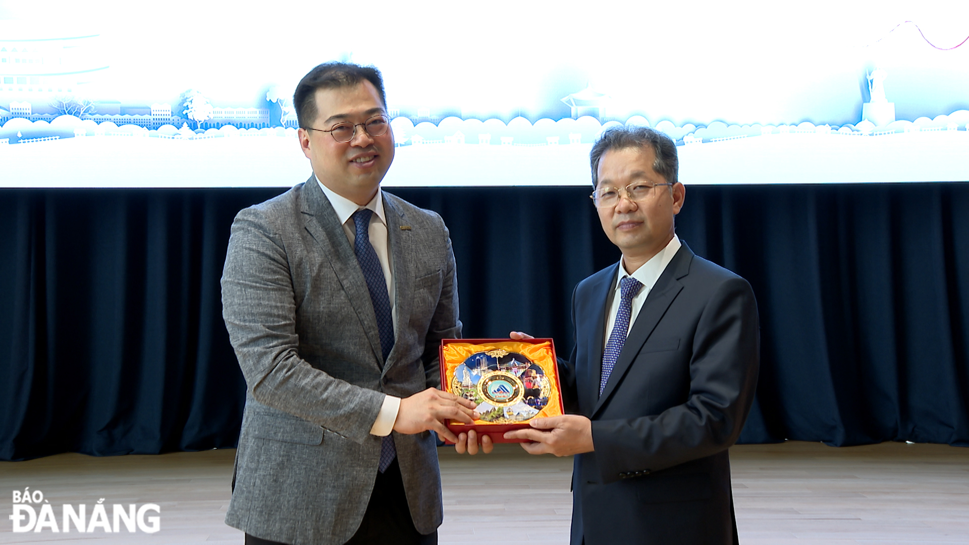 Da Nang Party Committee Secretary Nguyen Van Quang (right) giving a souvenir gift to leader of the Dentium company