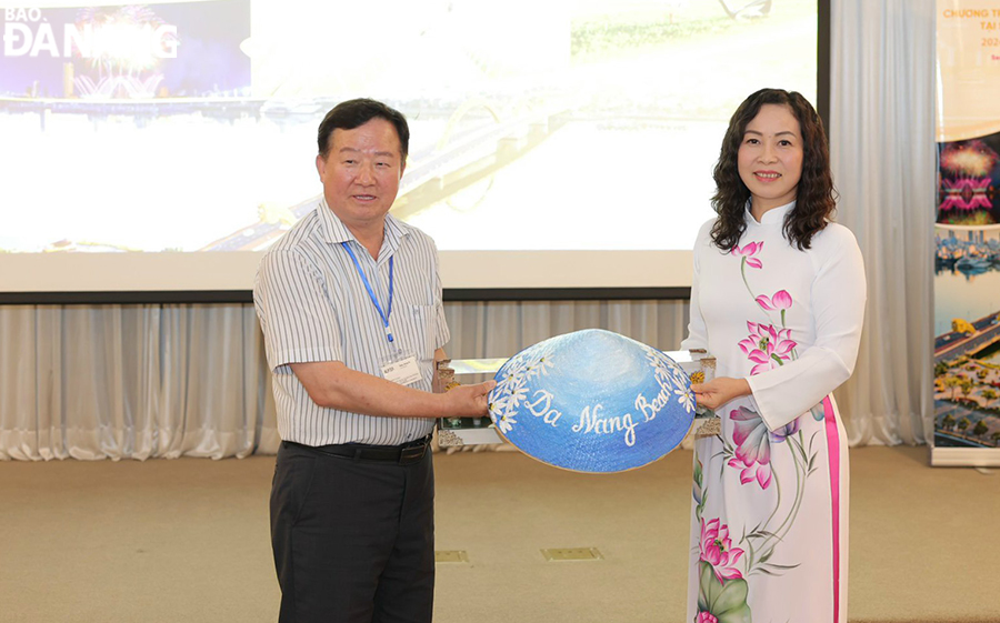 Director of the Da Nang Department of Tourism Truong Thi Hong Hanh (right) giving a gift to a Korean partner. Photo: Working group