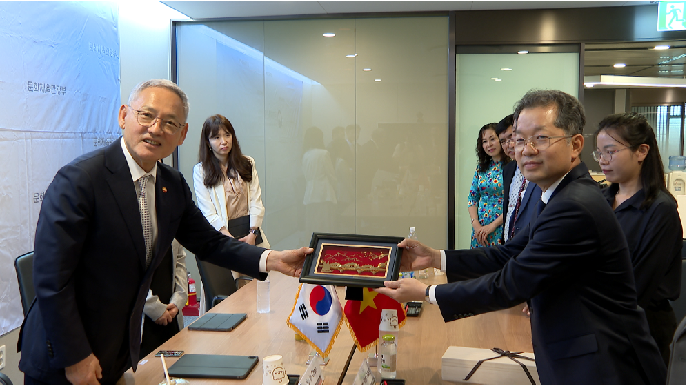 Da Nang Party Committee Secretary Nguyen Van Quang (right) presenting a souvenir gift to Minister of Culture, Sports and Tourism of RoK Yoo In Chon 