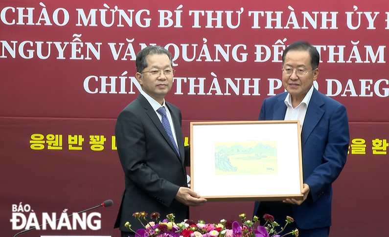 Leaders of Da Nang and Daegu giving souvenirs to each other. Photo: HOAN VU