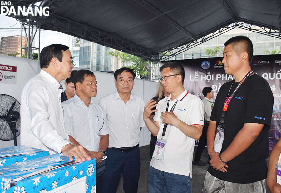 Da Nang People's Committee Chairman Le Trung Chinh (left) talking with representatives from the Chinese fireworks team. Photo: THU HA