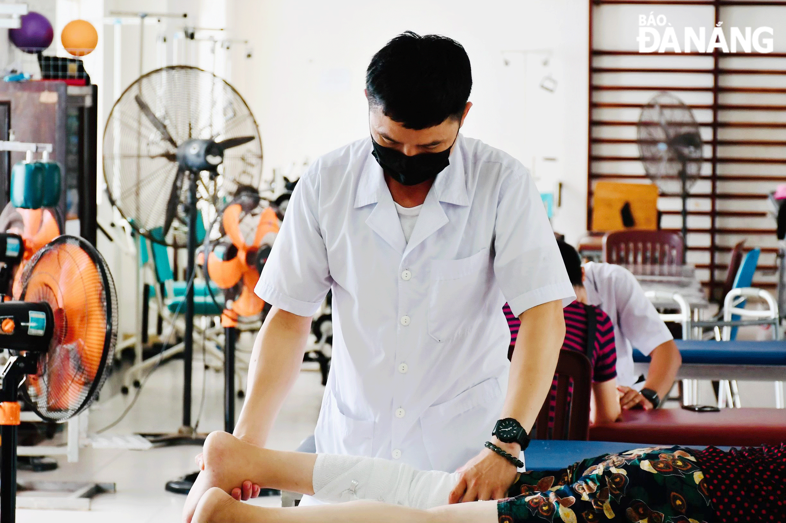 Physical Therapy and Rehabilitation Technician Dinh Quoc Hung assisting a patient in regaining motor functions. Photo: T.Y.