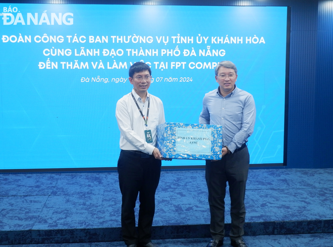 Secretary of Khanh Hoa Provincial Party Committee Nguyen Hai Ninh (right) presenting a souvenir to leaders of FPT Software Da Nang Company Limited. Photo: M.Q