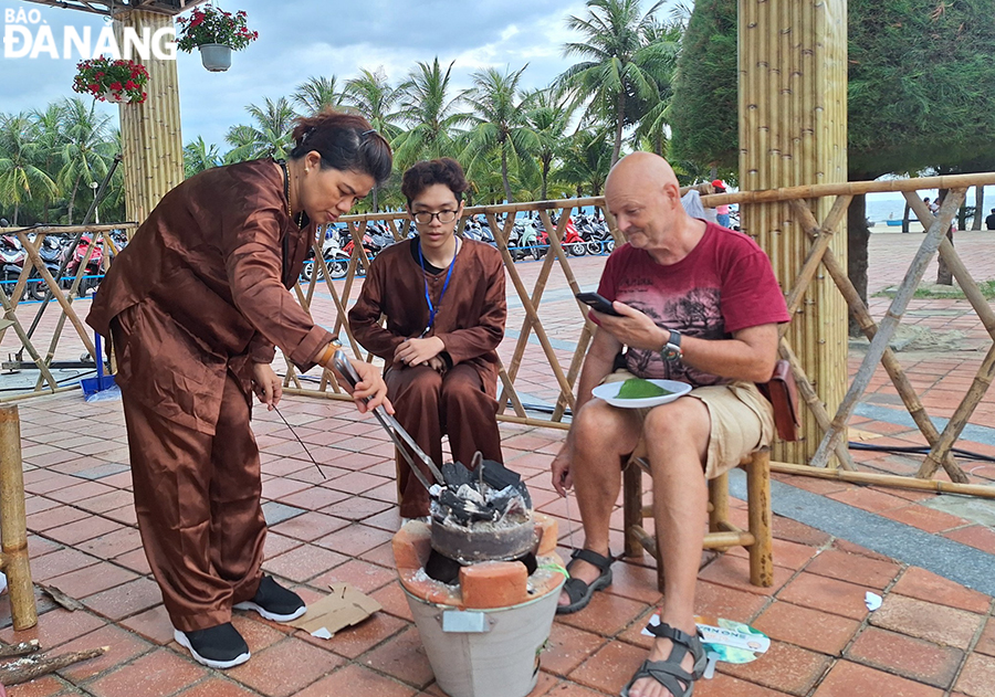 Du khách quốc tế thích thú với hoạt động làm bánh thuẫn.