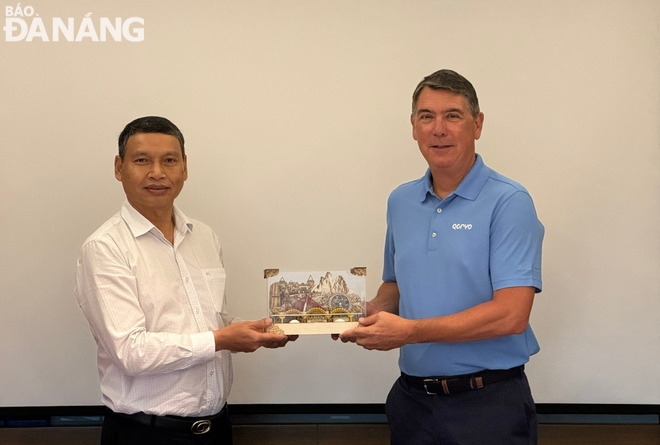 Standing Vice Chairman of the Da Nang People's Committee Ho Ky Minh (left) presenting a souvenir gift to the Qorvo Company leader