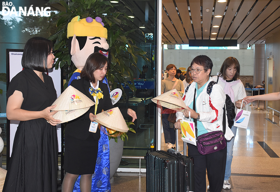 Passengers on the Hong Kong Airlines-operated first flight are given gifts upon arrival in Da Nang. Photo: THU HA