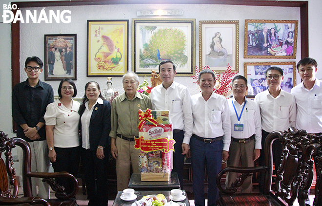 Chủ tịch UBND thành phố Lê Trung Chinh (thứ 3, bên phải sang) tặng quà cho gia đình thương binh ¾ Ngô Chí Nguyện. Ảnh: X.D