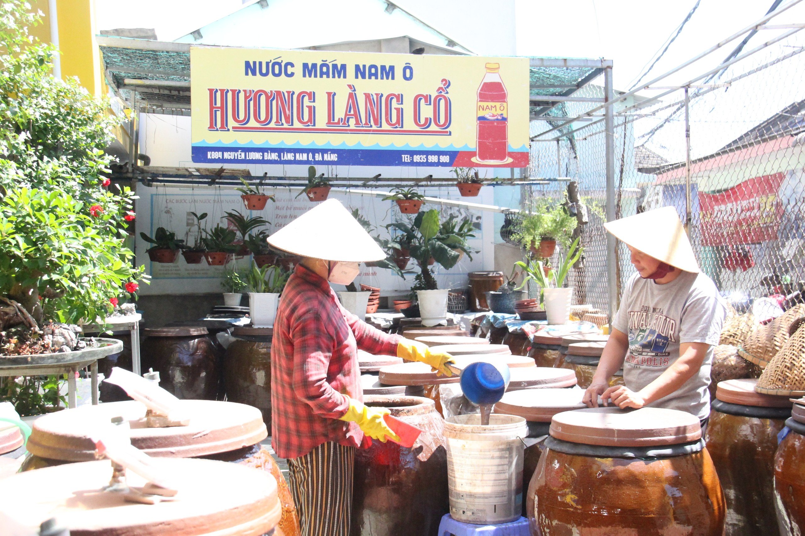 Mr. Bui Thanh Phu's family is checking the fish sauce production process. Photo: VAN HOANG