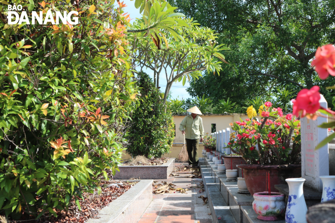 Mr Tinh sweeps fallen leaves, one of his daily tasks at the Hoa Tien Martyrs' Cemetery in Hoa Vang District