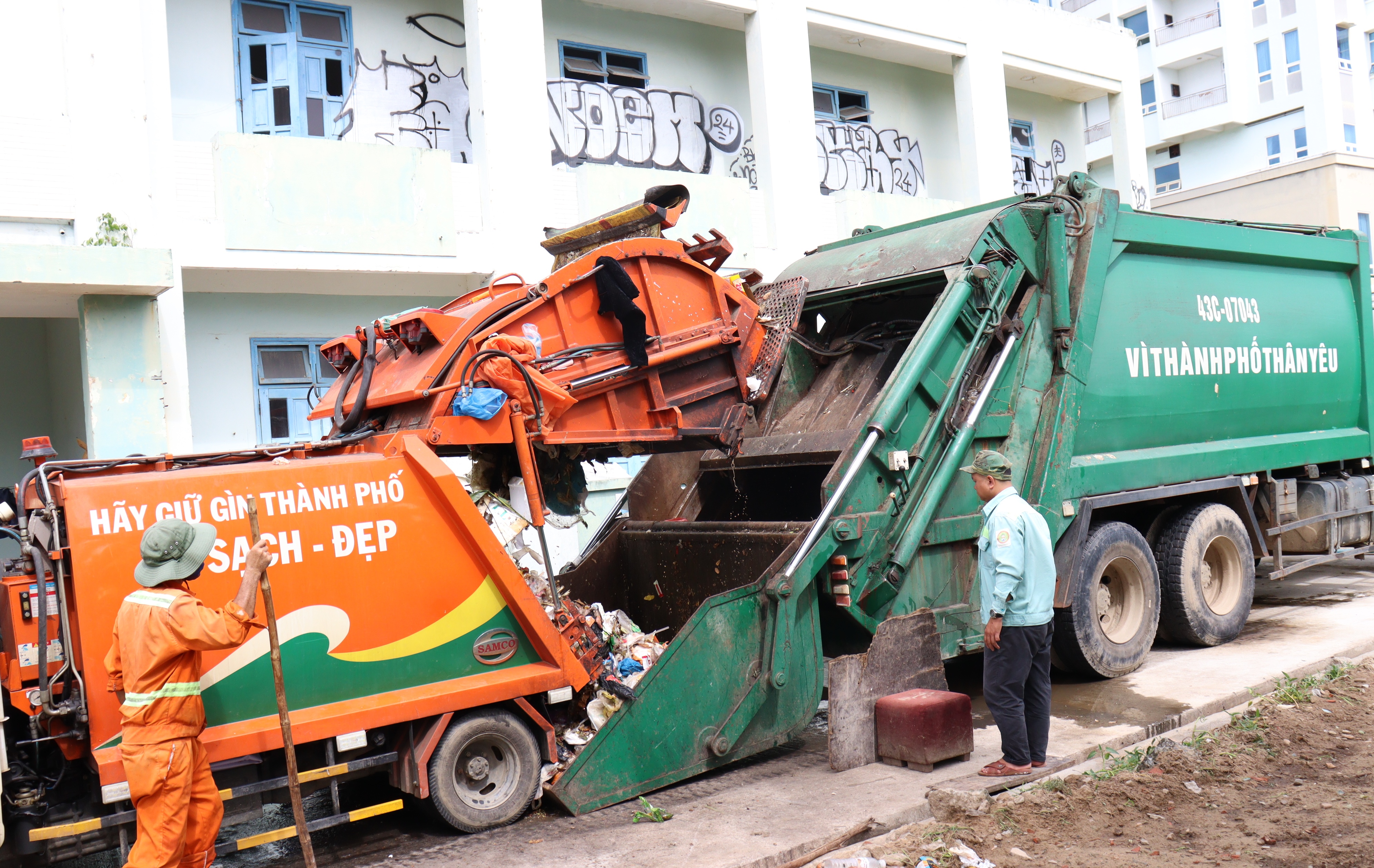 Tại phường Mỹ An (quận Ngũ Hành Sơn) rác sau thu gom được trung chuyển từ xe cuốn ép loại nhỏ sang xe có máng hứng để vận chuyển lên bãi rác Khánh Sơn.  Ảnh: PHƯƠNG VŨ