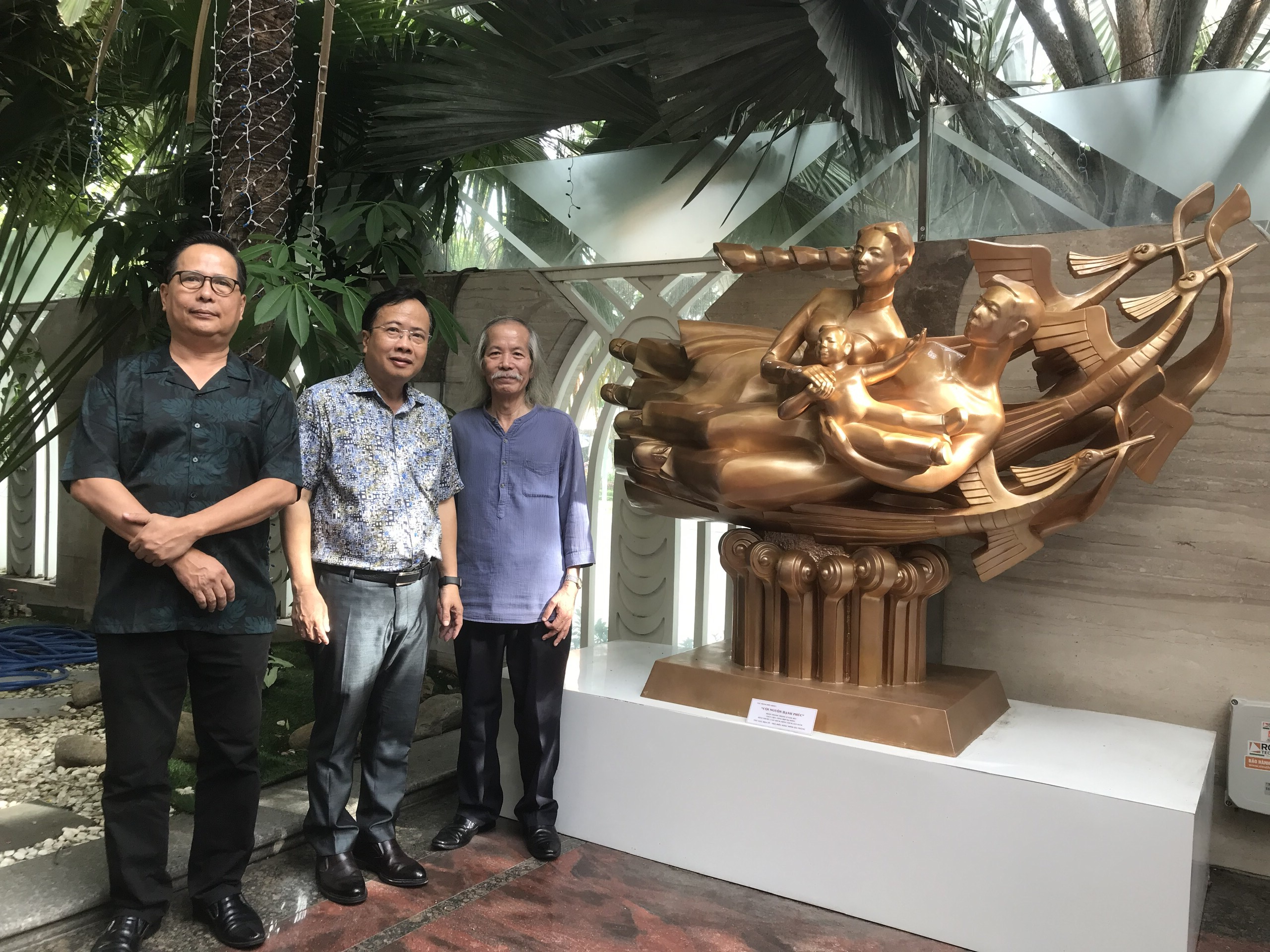 Sculptor Dinh Gia Thang (middle) and his work 