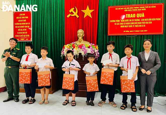 Bộ đội Biên phòng thành phố Đà Nẵng trao quà cho các học sinh trong chương trình “Nâng bước em tới trường - Con nuôi đồn biên phòng”. Ảnh: DOÃN QUANG