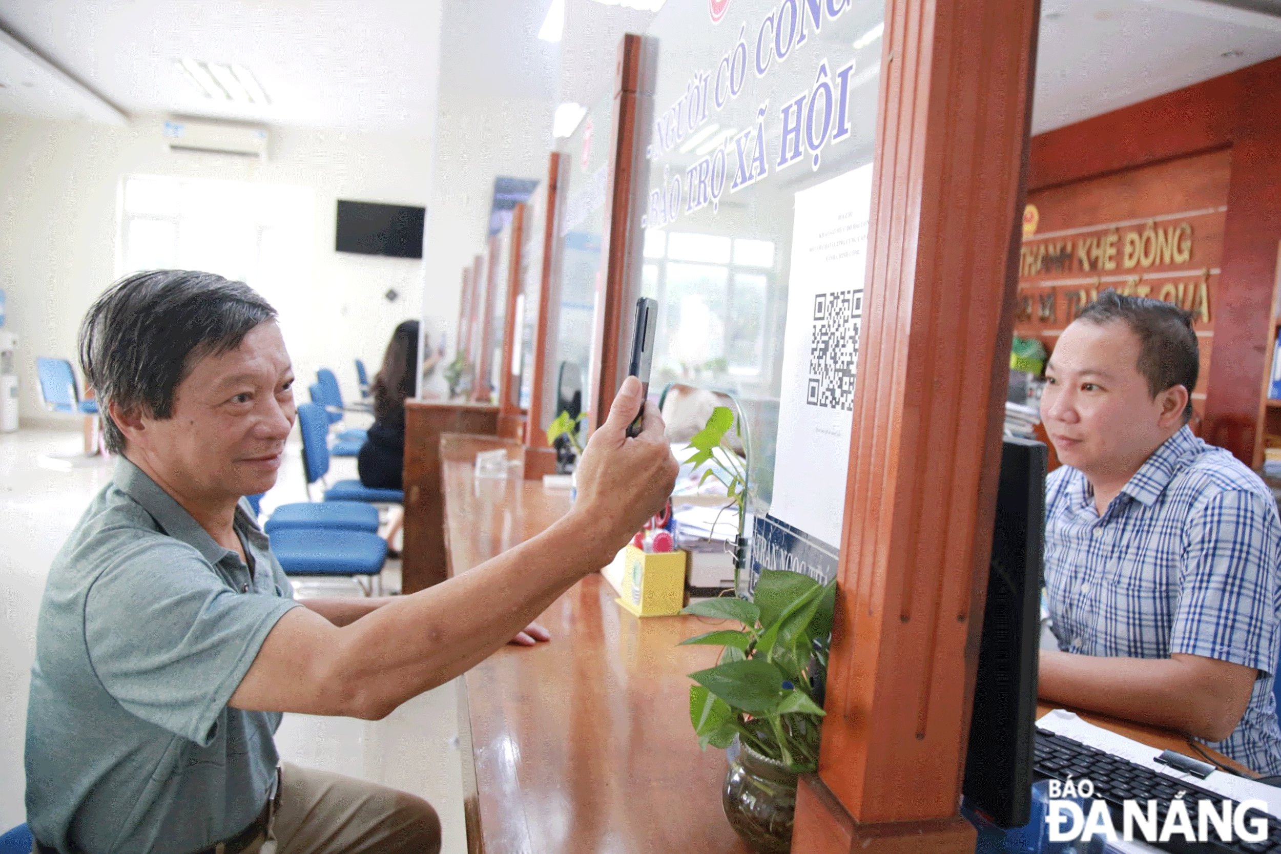 A local scanning QR codes to perform public procedures online at the headquarters of the Thanh Khe Dong Ward People's Committee. Photo: M.Q