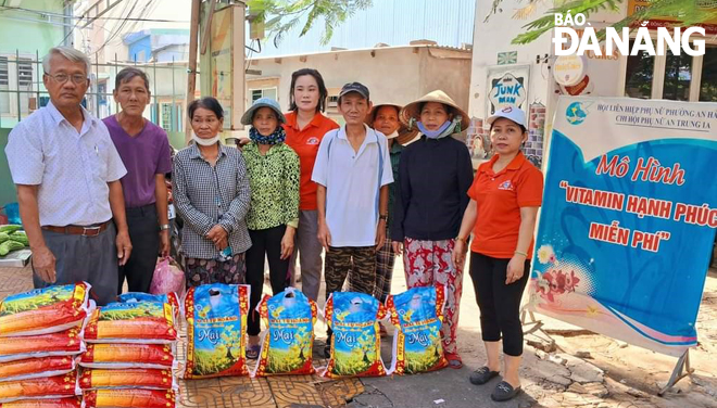 Chị Huỳnh Thị Lê (thứ 5, từ trái qua) cùng hội viên, phụ nữ Chi hội Phụ nữ An Trung 1A trao tặng nhu yếu phẩm cho bà con theo mô hình “Vitamin hạnh phúc”