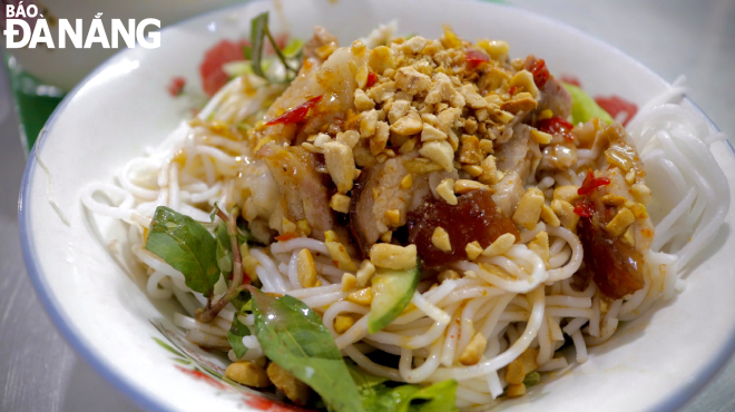 The ingredients of a bowl of ‘bun mam nem’ include rice vermicelli, roasted pork/‘nem chua’ (fermented pork)/‘cha bo’ (beef paste), raw vegetables, boiled chopped young jackfruit, roasted peanuts, simmered chili paste, and a sufficient amount of ‘mam nem’ (fermented anchovy dipping sauce) on top.