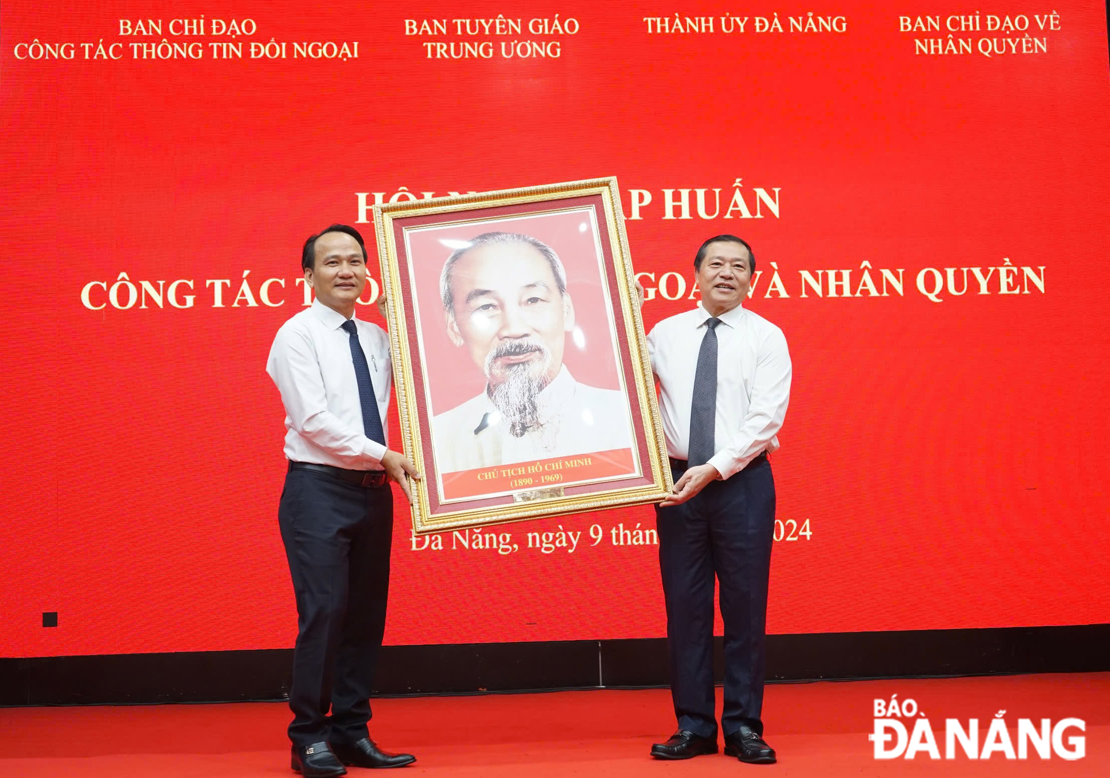 Standing Deputy Head of the Central Committee’s Commission for Information and Education Lai Xuan Mon (right) presenting a photo of Uncle Ho to the Da Nang Party Committee. Photo: X.H