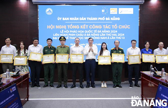 Chairman of the municipal People's Committee Le Trung Chinh (7th, left) awarding Certificates of Merit to collectives and individuals involved in organising DIFF 2024. Photo: X.D