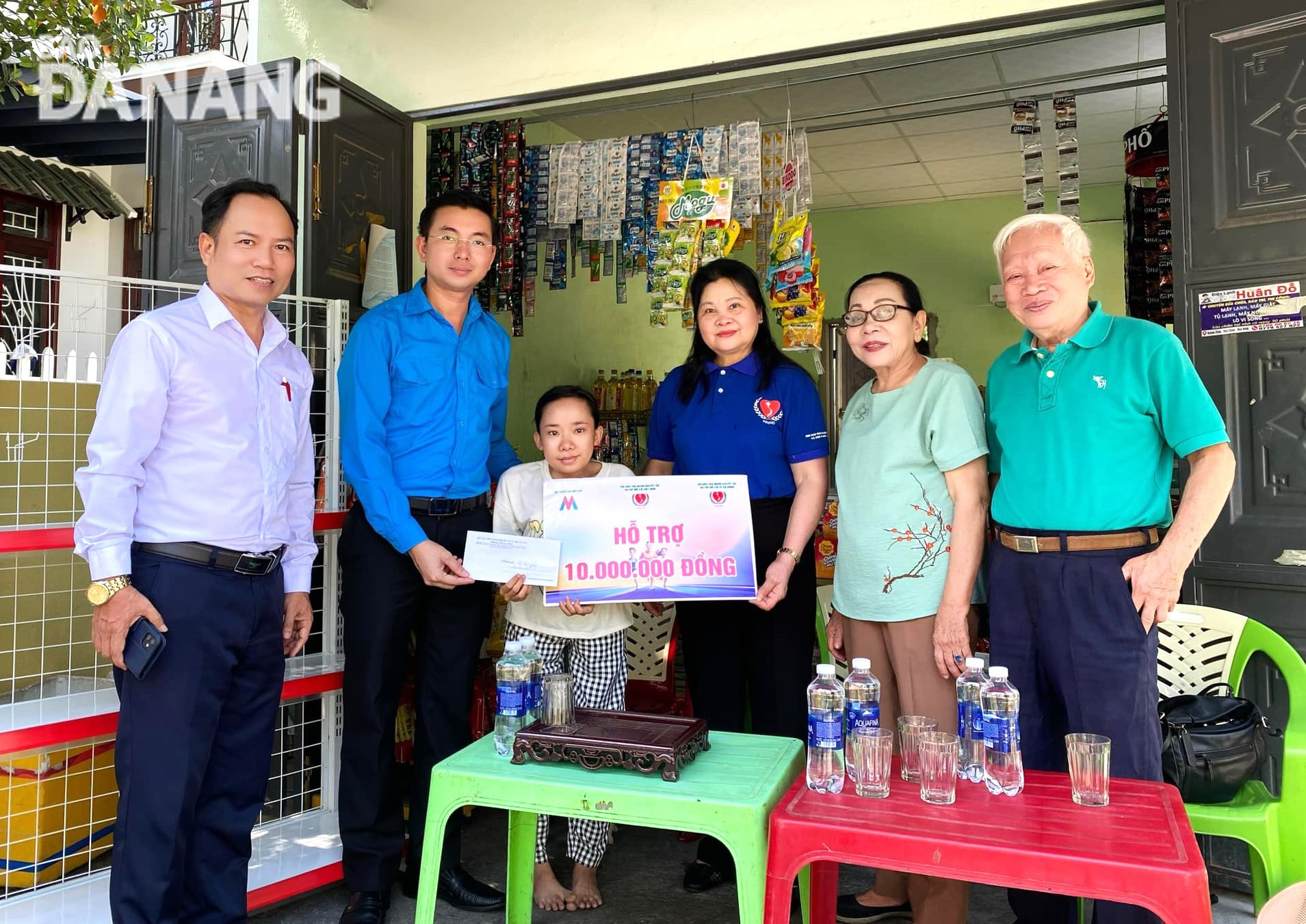 The Deputy Secretary of the municipal Youth Union, Nguyen Ba Duan (left, second) hands over a livelihood to a family of disadvantaged youth. Photo: L.P.