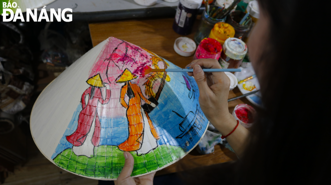 To complete a painting on a conical hat, it must go through many stages, including sketching, colouring, waiting for it to dry, colouring a second time, drawing lines, then completing the details and finally coating to ensure the durability of the paint.