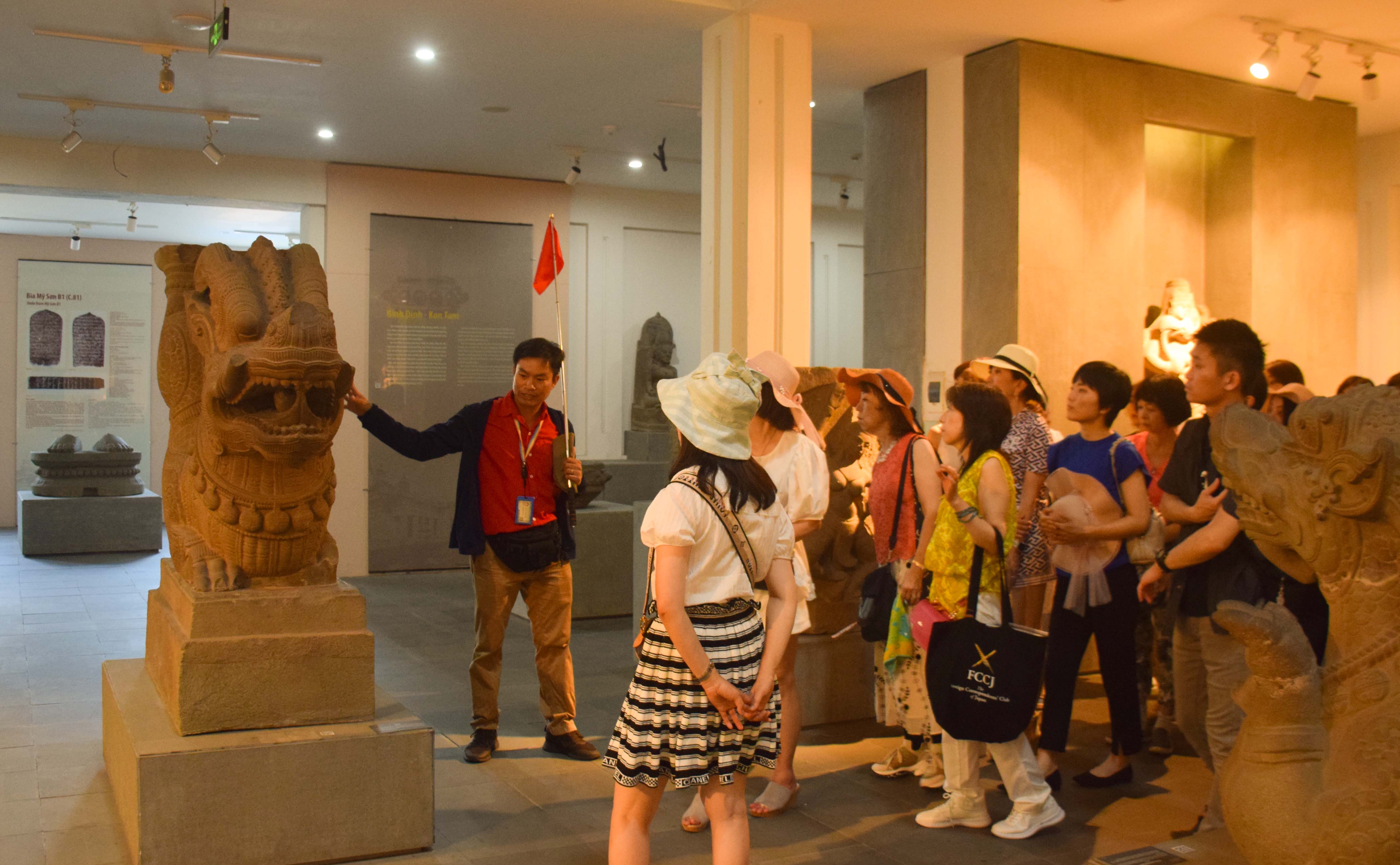 Tour guides are “ambassadors” who bring culture to the world. A tour guide is pictured explaining Cham culture to Japanese and South Korean tourists at the Da Nang Museum of Cham Sculpture. Photo: D.H.L